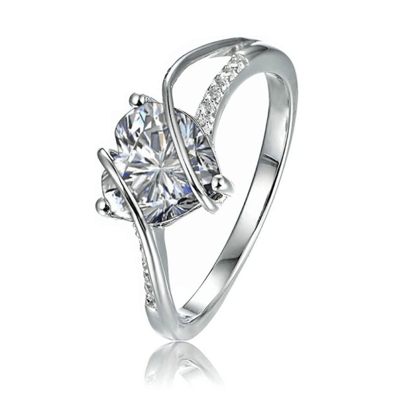 Silver engagement ring with a large cushion-cut diamond centerpiece and pavé accents on a curved band, shown at an angle with reflection.