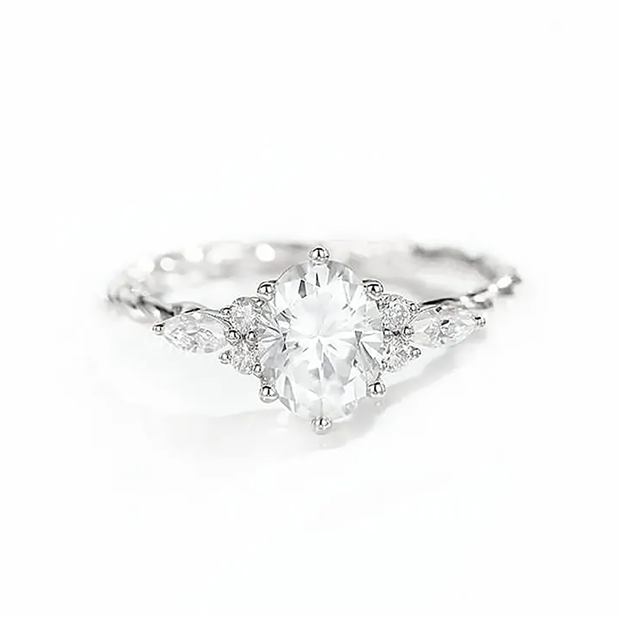 Diamond engagement ring with a large center stone and smaller diamonds along the band shoulders, set in white metal.