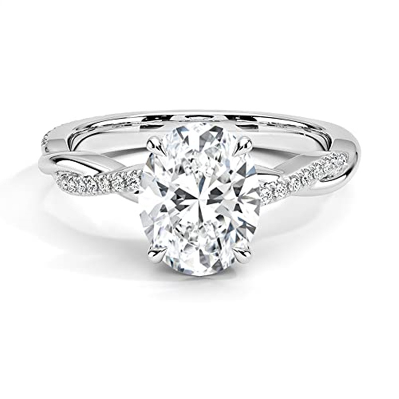 Engagement ring with a large oval diamond in a four-prong setting and pavé diamonds along the band on a silver metal band.