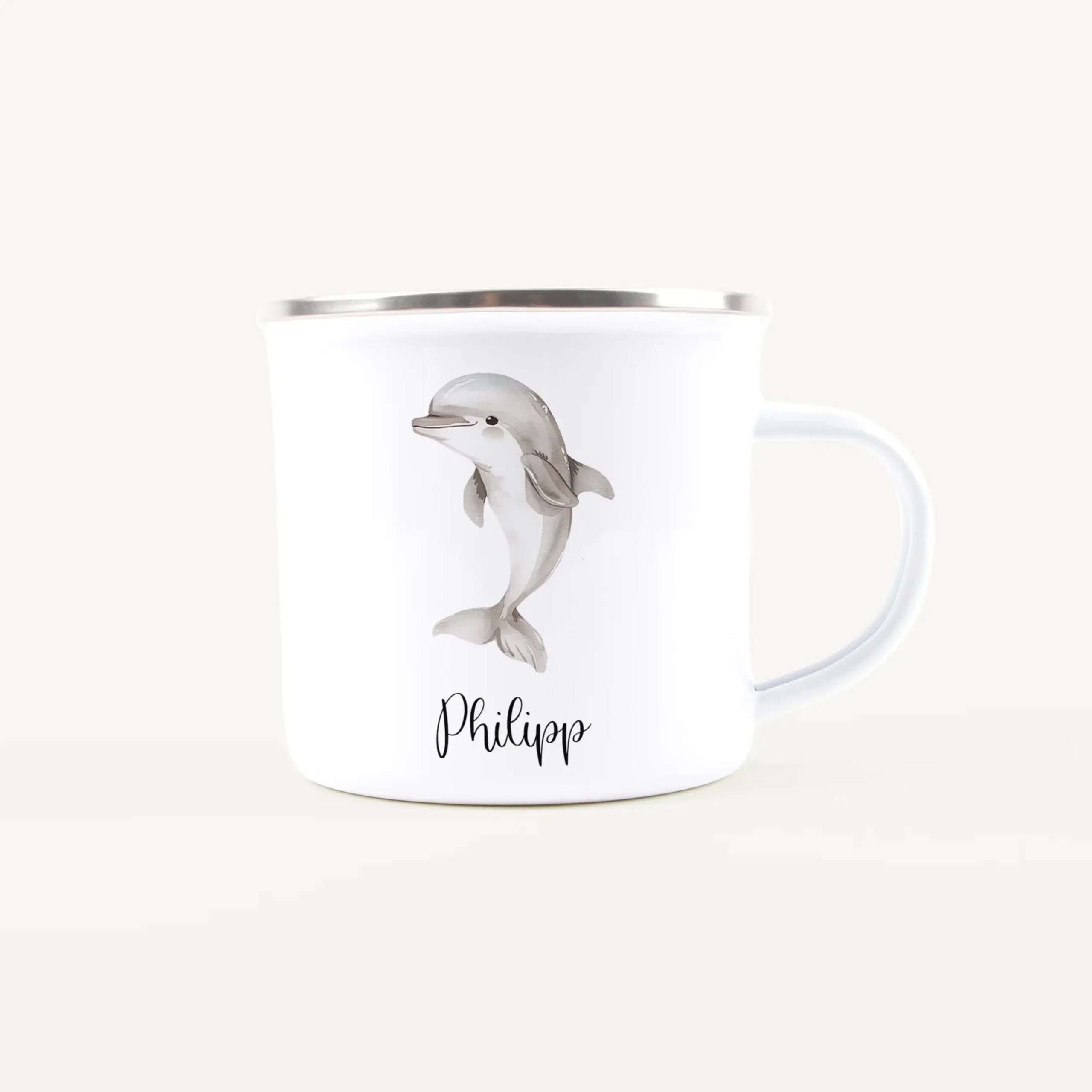 White ceramic mug with a silver rim featuring a gray dolphin illustration and the name Phillip in elegant black script on the side.