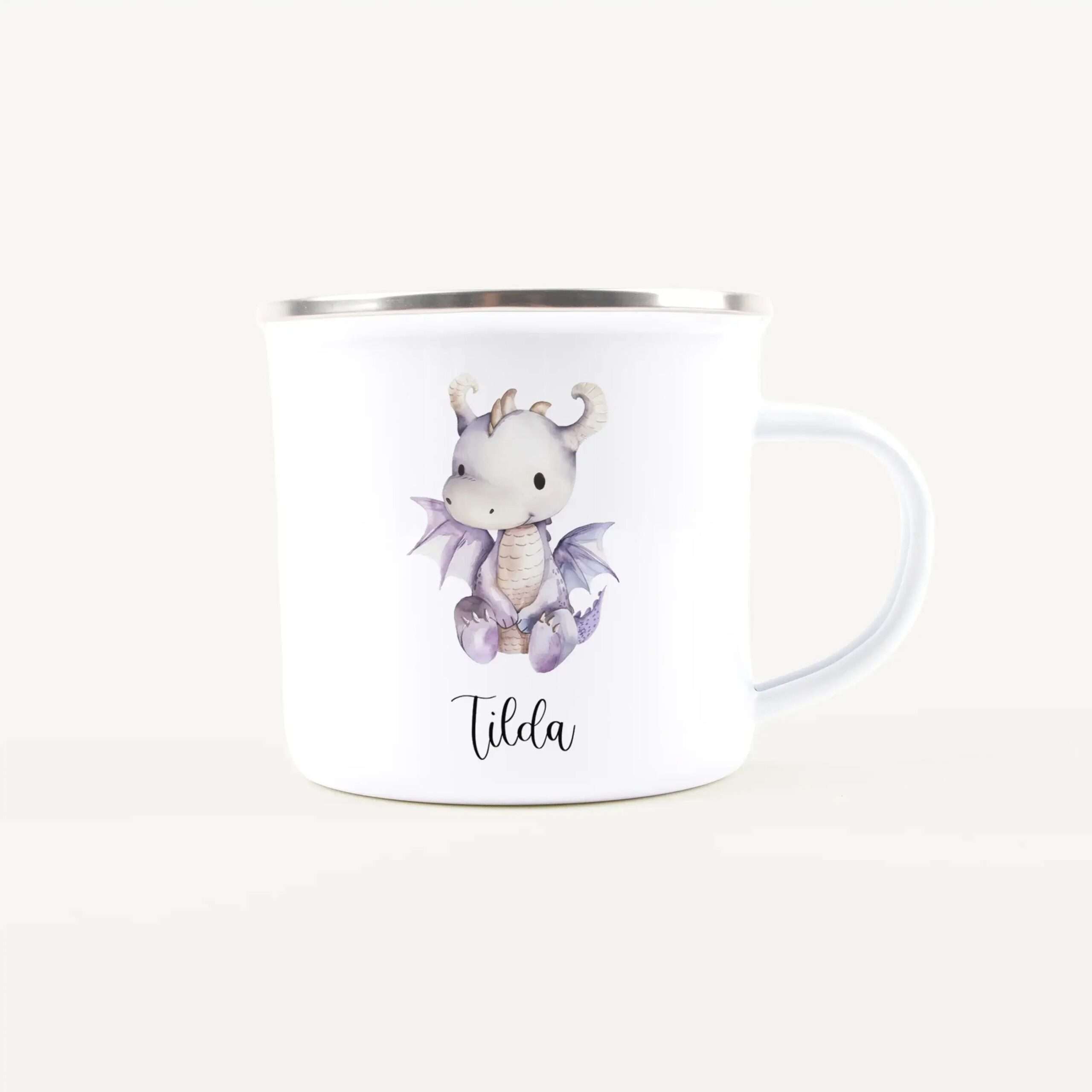 White ceramic mug featuring a pastel dragon illustration and the name "Tilda" in cursive (partial handle visible).