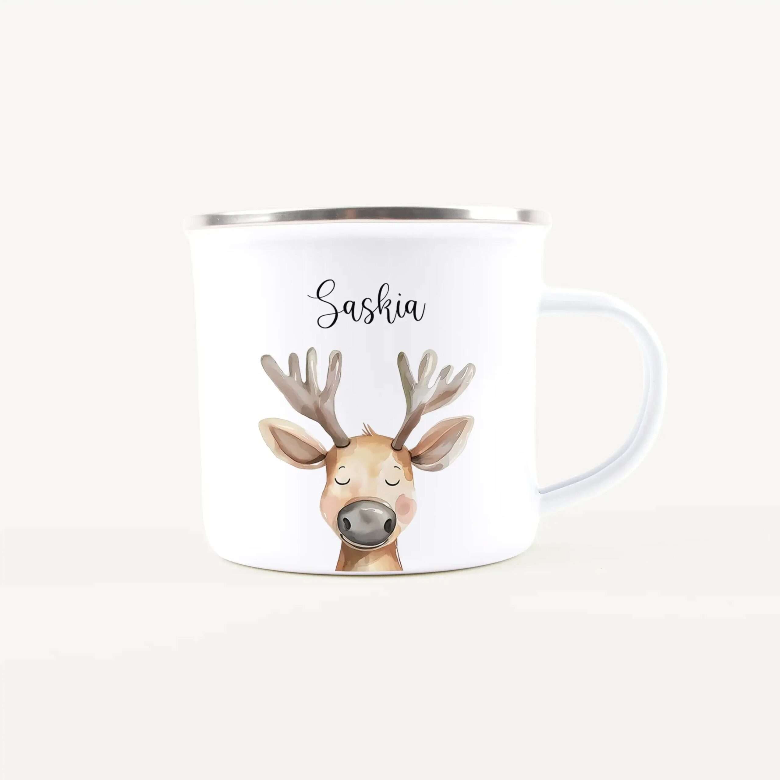 White ceramic mug featuring a cute illustrated reindeer head and the name Saskia, with a silver rim on top edge.