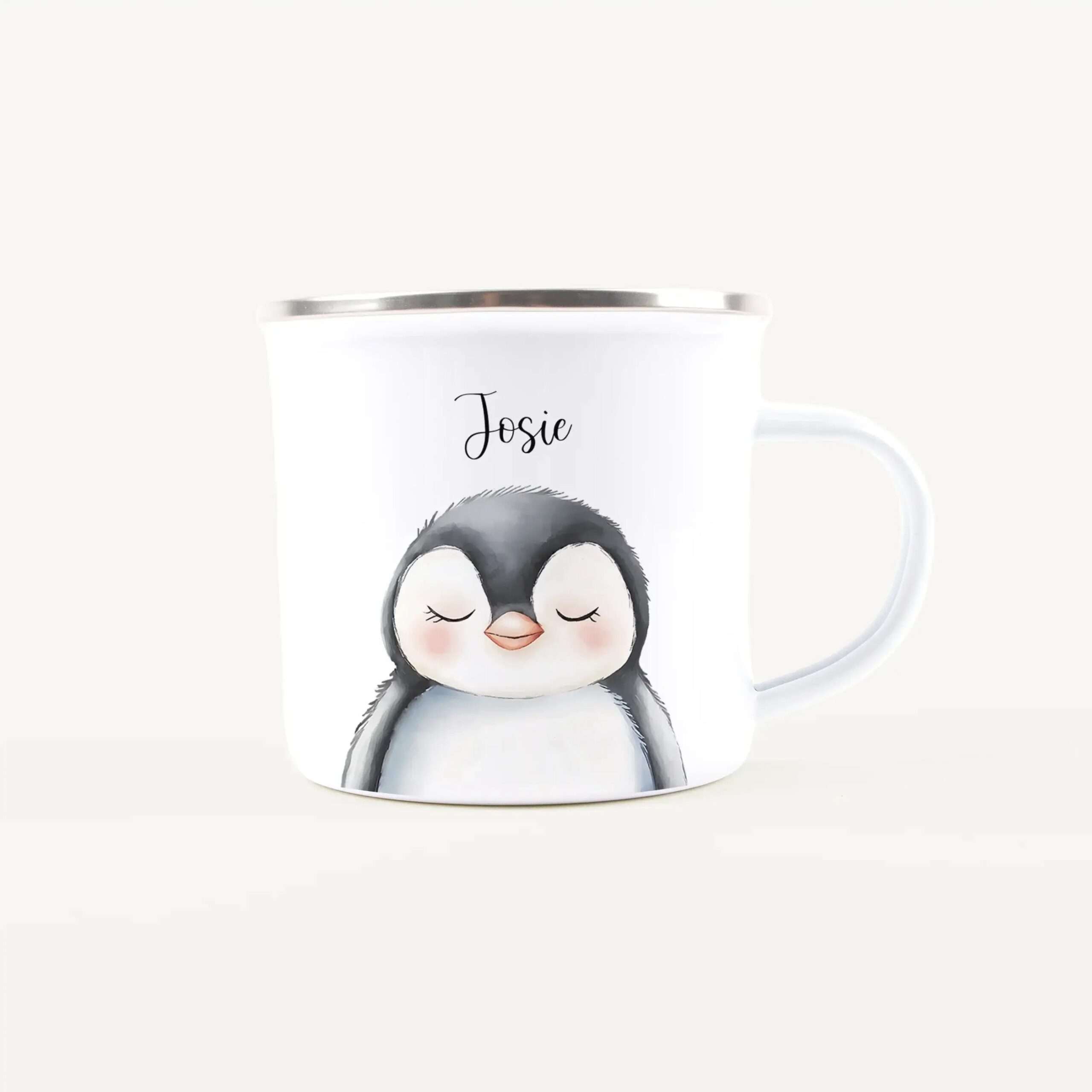 White ceramic mug with a silver rim, showing a cute sleeping penguin illustration and the name Josie above it.