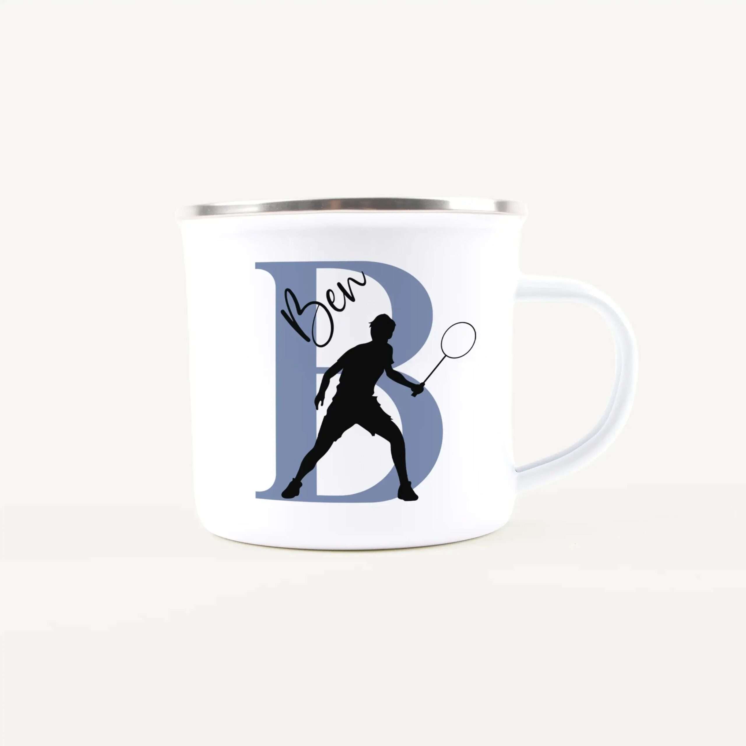White ceramic mug with a large blue letter D and a black silhouette of a person swinging a racket, plus cursive text design.