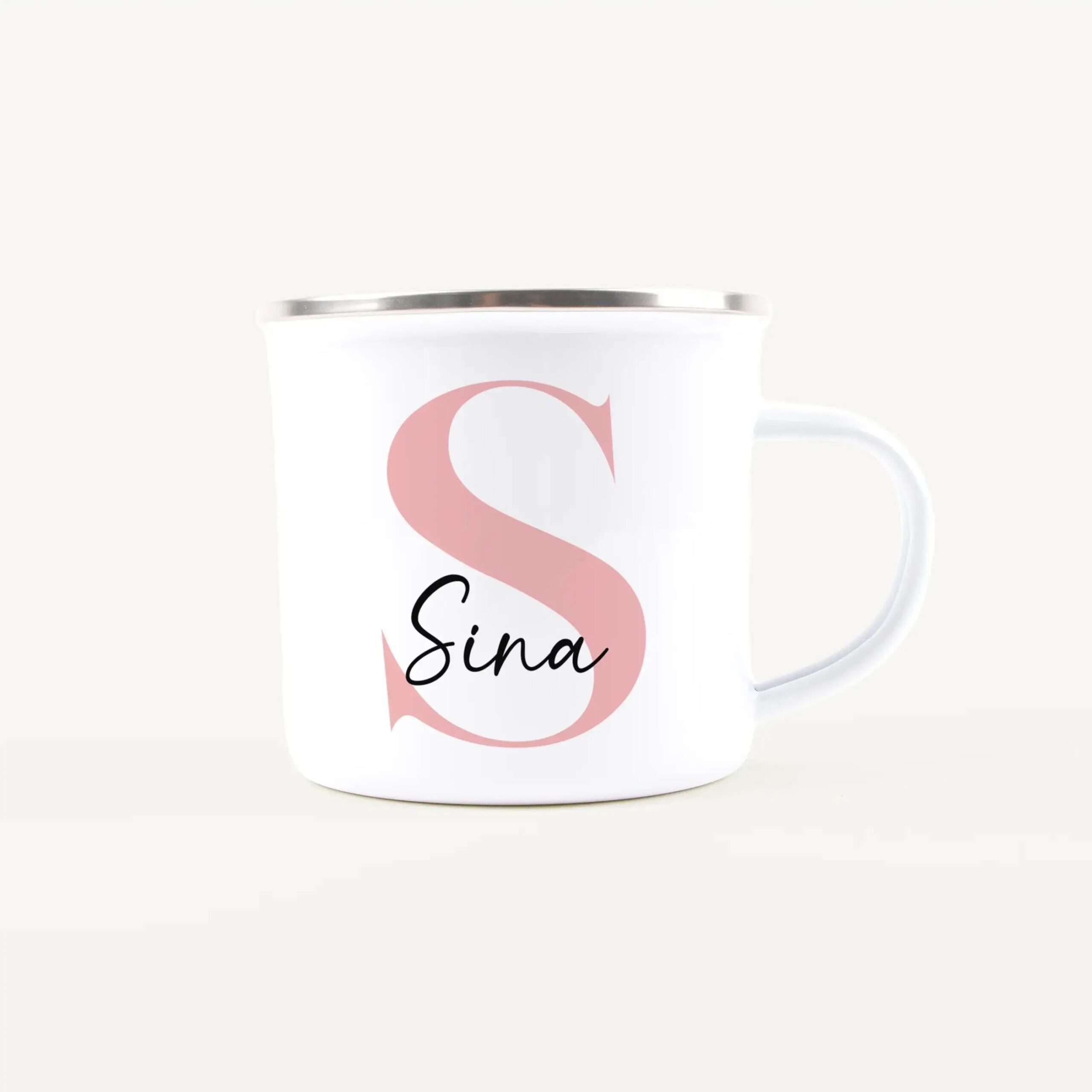 White ceramic mug with a pink decorative swirl and partial black cursive text 'Sina' visible on a light background.