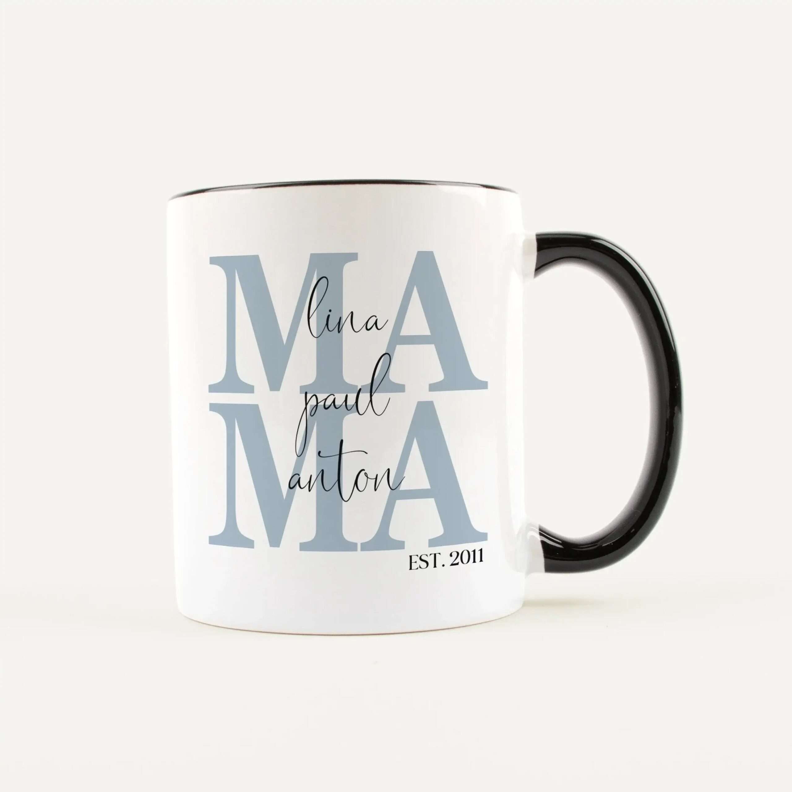 White ceramic mug with large blue 'MAMA' lettering and a black handle; cursive name across the front.