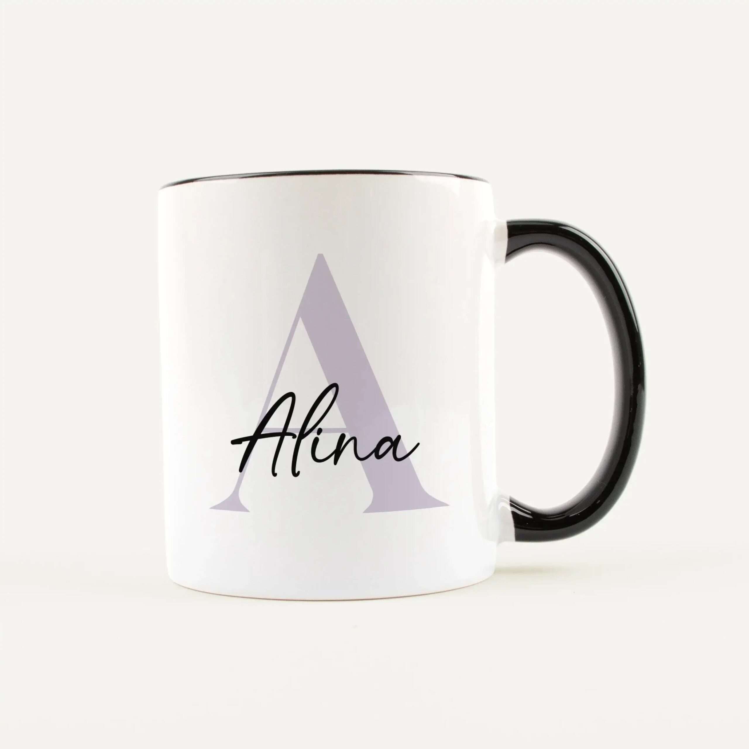 Close-up of a white mug with a light purple triangle and black script text, handle on the right.