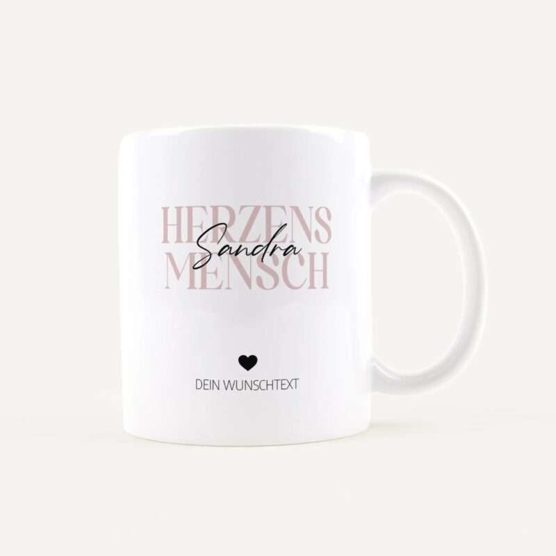 White mug featuring large pink text reading 'HERZEN' with a black cursive name over it, a small heart icon, and the placeholder 'DEIN WUNSCHTEXT' below.