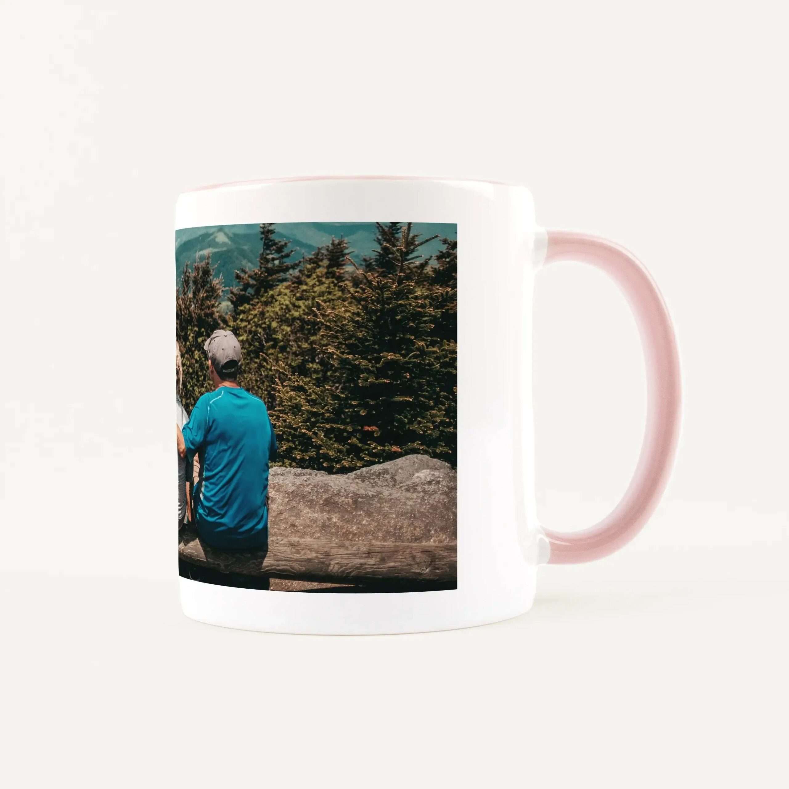 White mug with a printed photo of hikers walking along a forested trail.