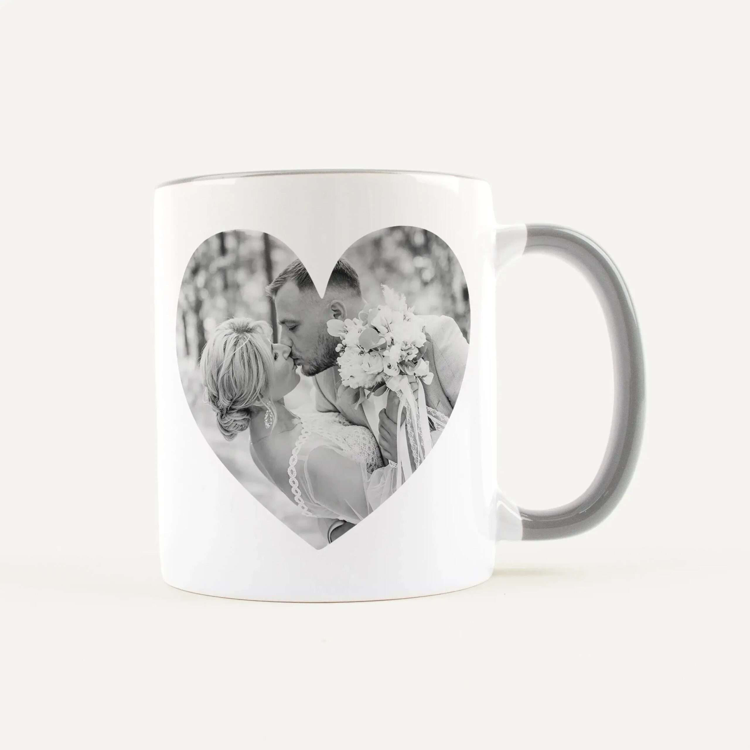 White ceramic mug with a black-and-white photo of a couple kissing inside a heart-shaped cutout, bouquet visible.