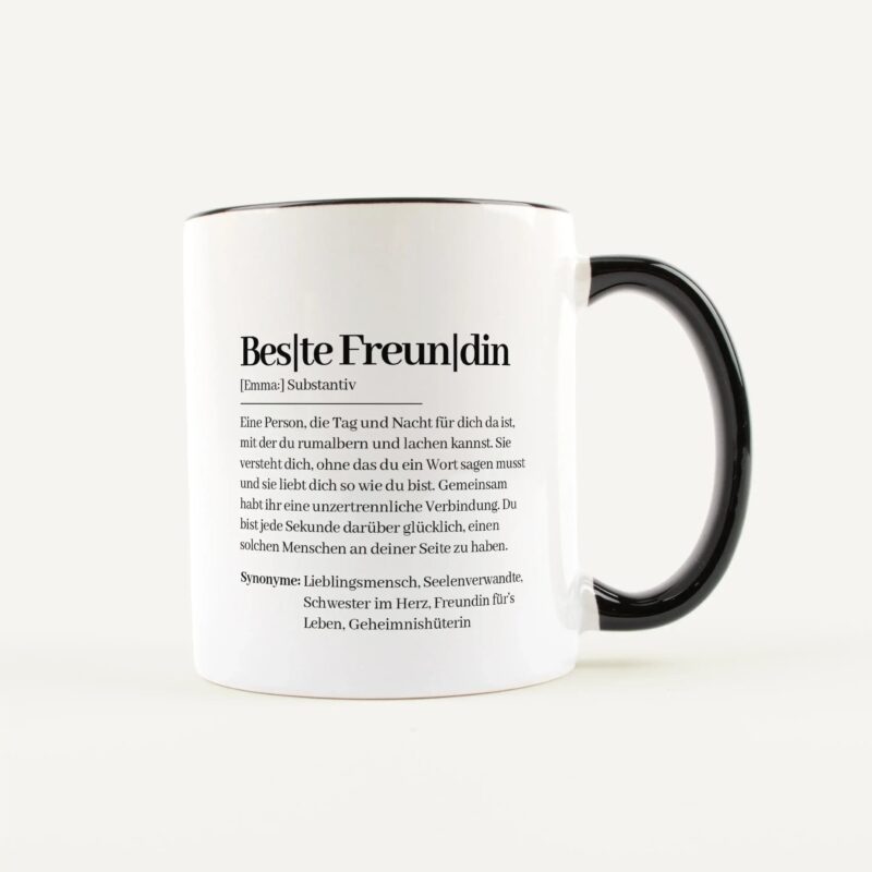 White ceramic mug with black handle and German text printed along the side, visible in a close-up.