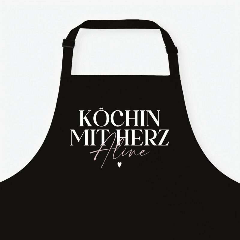Black apron with bold white German text reading 'Köchin mit Herz' and a pink cursive word, set against a light background.