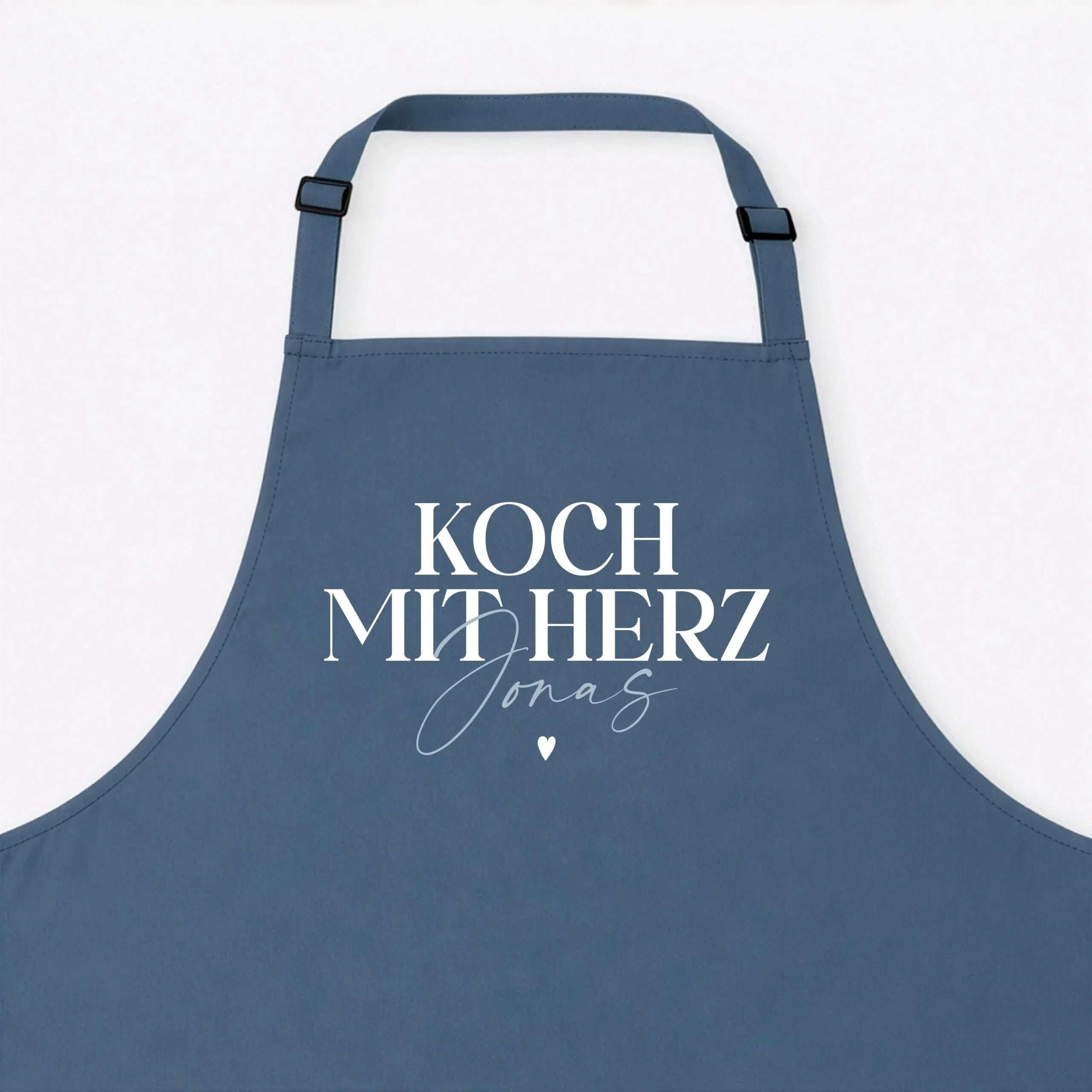 Blue apron with white 'KOCH MIT HERZ' text and a small heart motif at the bottom.