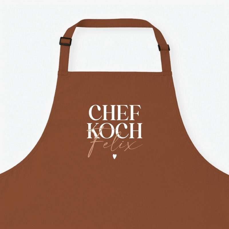 Close-up of a brown apron with adjustable straps against a white background; large white 'CHEF' text visible.