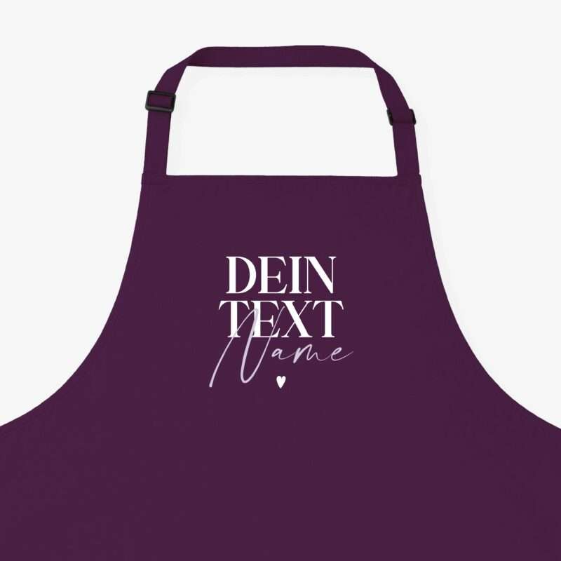 Purple apron worn or displayed from the chest up, showing adjustable straps and white script text on the front.