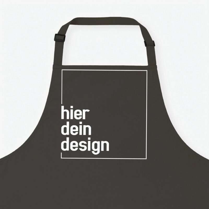 Close-up of a black apron with a white rectangular outline and partial white text that reads 'design' on a light background.