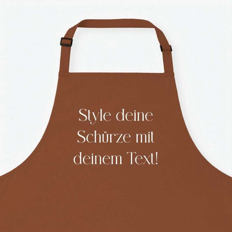 Close-up of a brown apron with adjustable straps and bold white German text overlay reading ‘Style deine Schürze mit deinem Text!’