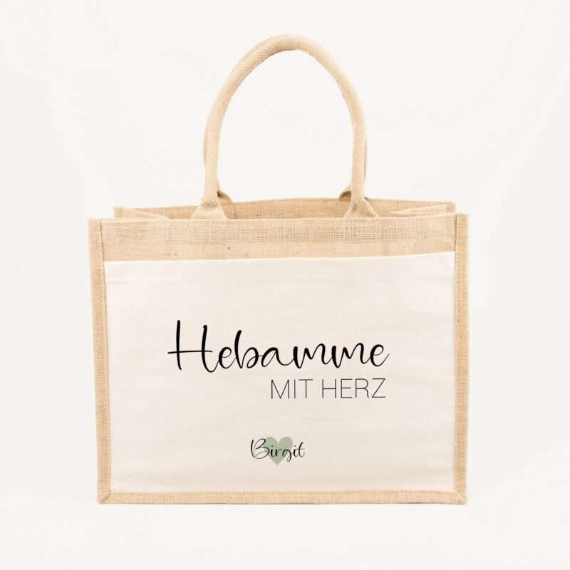 Beige burlap tote bag with black script text reading 'Hebamme MIT HERZ' and a small heart icon with the name Birgit at the bottom.